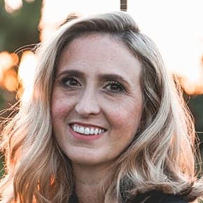 Smiling woman with curly blonde hair outdoors