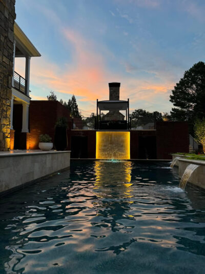 Sunset reflection on a pool with waterfall.