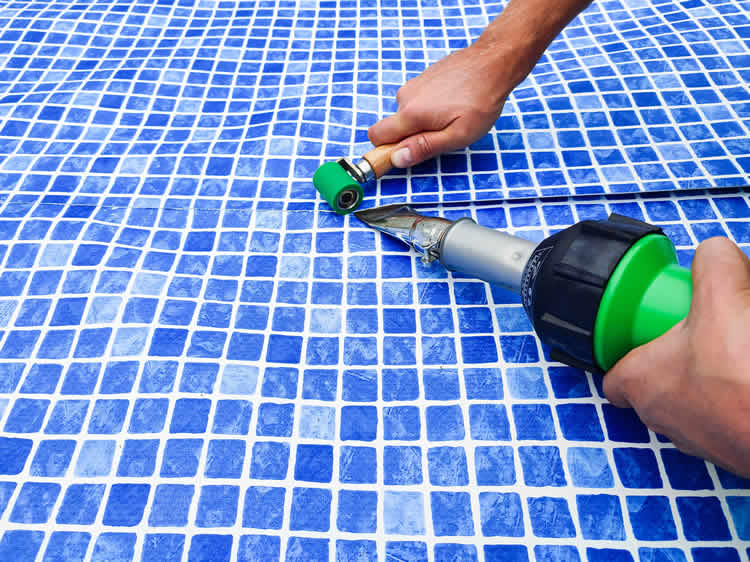 Installing blue pool liner with heat tool