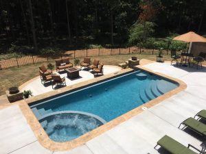 Rectangular pool with patio furniture in backyard