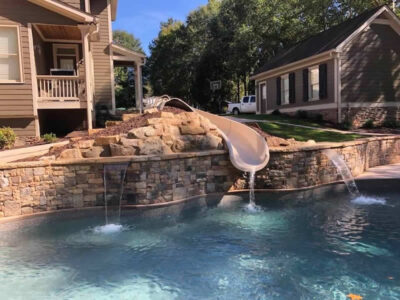 Backyard pool with waterslide and waterfalls.