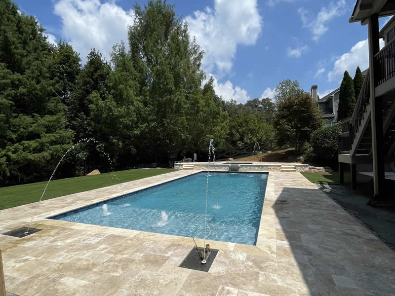 Backyard pool with fountains and patio