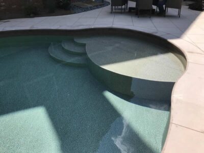 Curved swimming pool with built-in steps