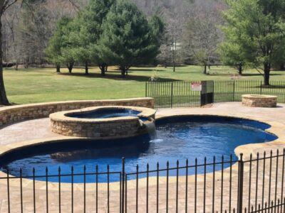 Outdoor pool with surrounding landscape and trees.