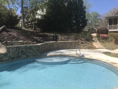 Backyard pool with stone wall and slide