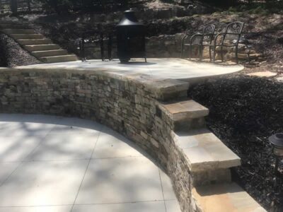 Stone patio with stairs and seating area.