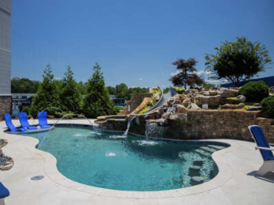 Backyard pool with slide and waterfall feature.
