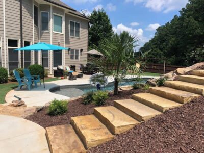 Backyard pool area with seating and steps