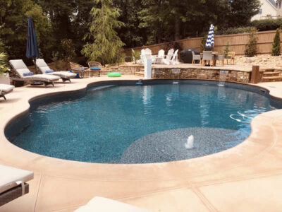 Backyard pool with lounge chairs and fountain