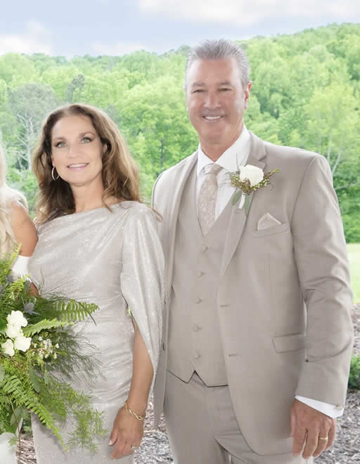 Smiling couple posing at outdoor wedding.