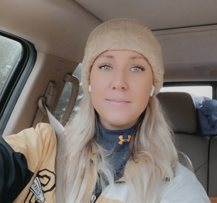 Woman in car wearing a hat and earphones.