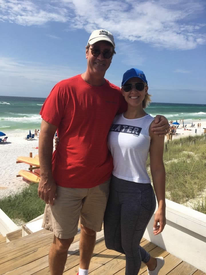 Two people smiling on a sunny beach