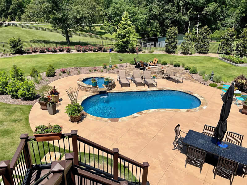 Backyard with pool and lounge chairs.