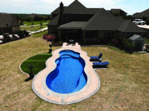 Aerial view of backyard pool beside suburban home
