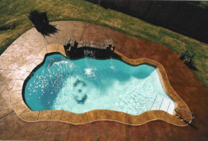 Aerial view of freeform backyard swimming pool with waterfall