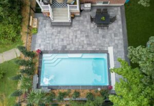 Aerial view of backyard pool, patio, and dining area
