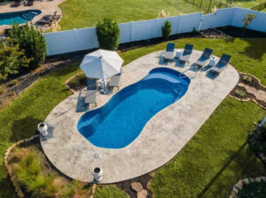 Aerial view of backyard pool with lounge chairs and umbrella