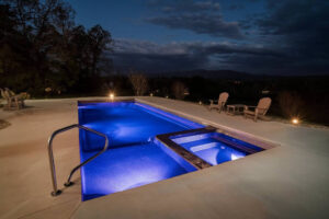 Illuminated infinity pool and spa at twilight